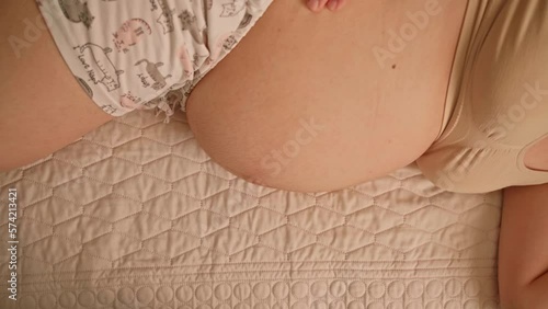 Pregnant woman lying on her side in bed for comfort during pregnancy photo