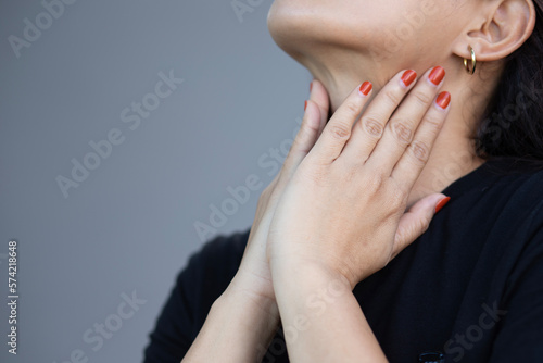 Beautiful young woman touching her sick neck with hands she has neck pain Sore throat Difficulty swallowing