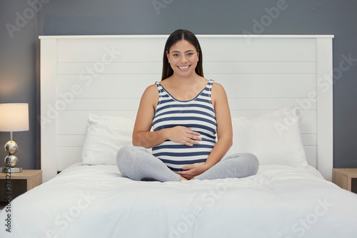 Excited, motherhood and portrait of a pregnant woman on a bed for peace, rest and touching stomach. Smile, baby and girl feeling her belly during a pregnancy, maternity leave and relax in the bedroom