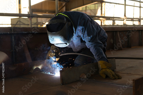 Fotomurale Welder welding a steel plate at a shipyard and a steel block in a naval sector a