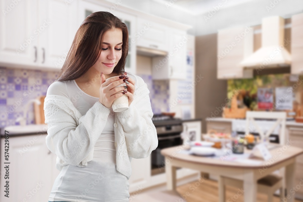 Young happy woman with aromatic coffee at kitchen Young happy woman with aromatic coffee at kitchen