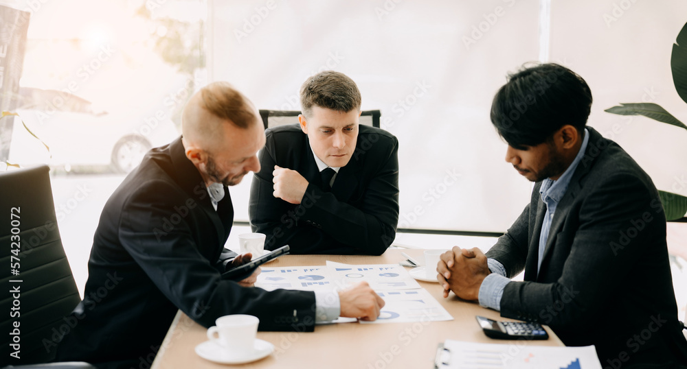 © Nuttapong punna - Business team discuss at meeting room. working together with laptop ,tablet and smart phone on desk Financial accountant , planner , meeting , introduction concept. At office.