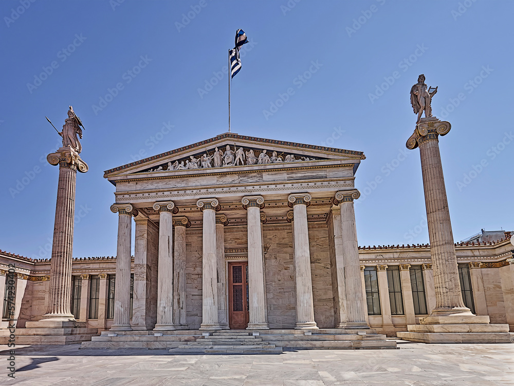 Front facade of the national academy with Athena and Apollo gods on Ionian columns and other ancient Greek gods and deities on the pediment. Cultural travel to Athens, Greece.