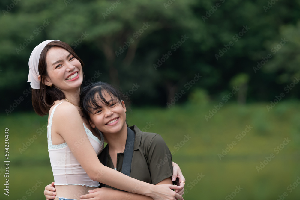 Fototapeta premium people and friendship concept - happy smiling teenage girls, Portrait of beautiful woman smiling and looking away at park during sunset. Happy cheerful girl laughing at park.