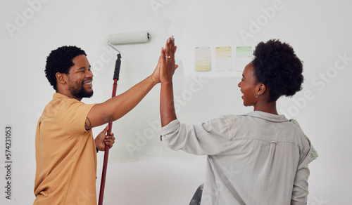 Painting  success or black couple high five in DIY  home renovation or house remodel together with a paintbrush. Happy smile  woman and fun African man with teamwork or support for decoration designs
