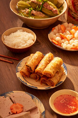 A Tet banquet with spring roll, soup and a bowl of rice. New year creative concept. Front view