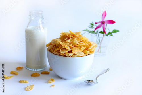 Cereali Cornflakes in una ciotola bianca e latte isolati su sfondo bianco.