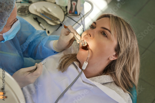 doctor stomatologist looks in a dental mirror the condition of the teeth of a young patient in a chair