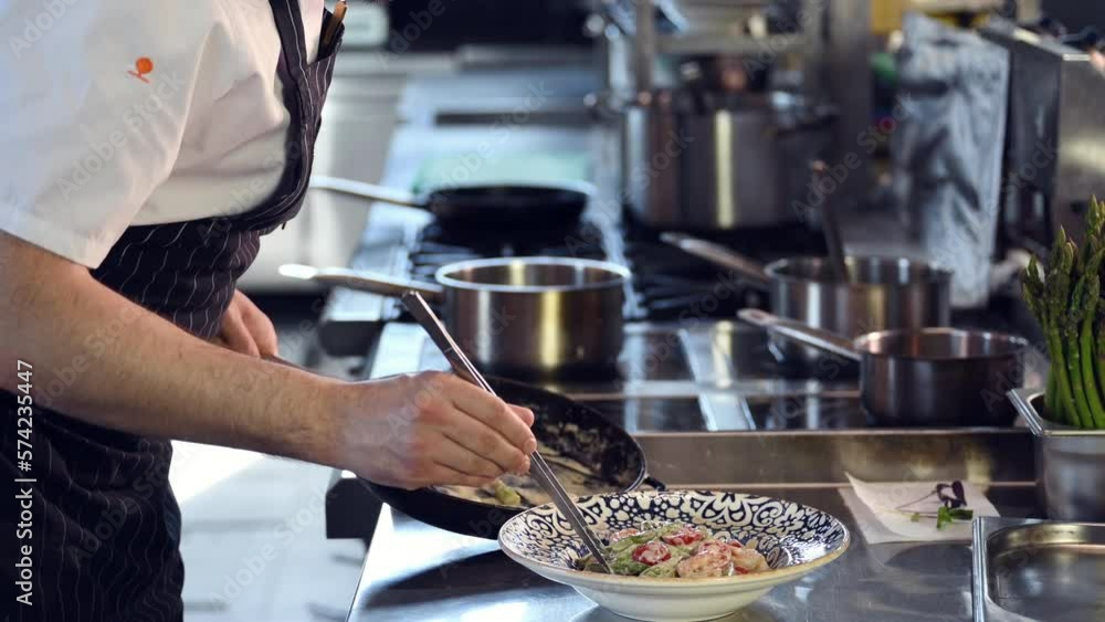 Close up view of the chef in uniform that prepares a salad on the kitchen. Close up view of the chef in uniform that prepares a salad on the kitchen.