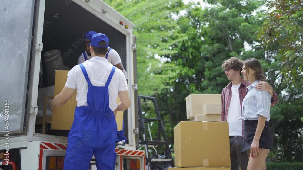 Team of employee workers with a truck car moving house for customers, delivering boxes with uniform.Vehicle transportation. Shipping and packaging business occupation service company. People lifestyle Team of employee workers with a truck car moving house for customers, delivering boxes with uniform.Vehicle transportation. Shipping and packaging business occupation service company. People lifestyle