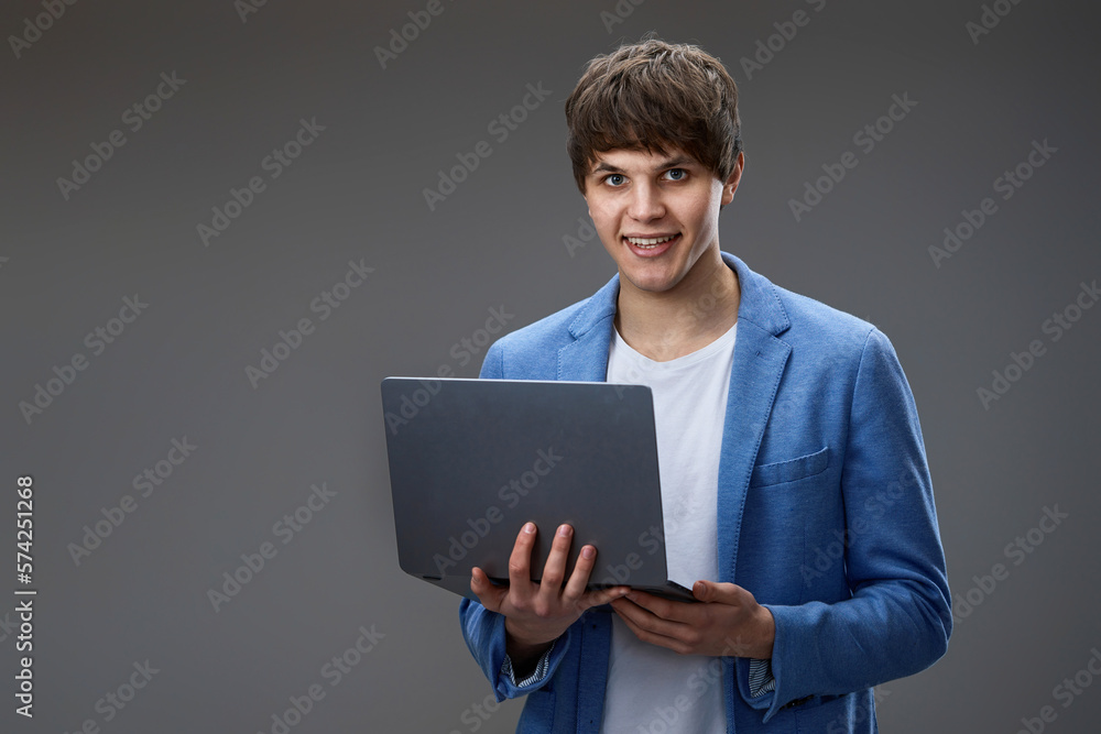 caucasian young man using laptop isolated on gray background caucasian young man using laptop isolated on gray background