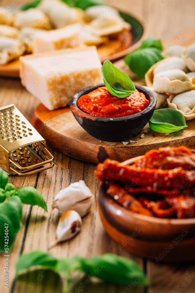 Home cooking - raw tortellini pasta with tomato pesto and sun-dried tomatoes and basil Home cooking - raw tortellini pasta with tomato pesto and sun-dried tomatoes and basil