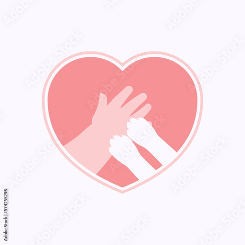 Small paws of cat on hand of kid, in pink heart shaped frame
