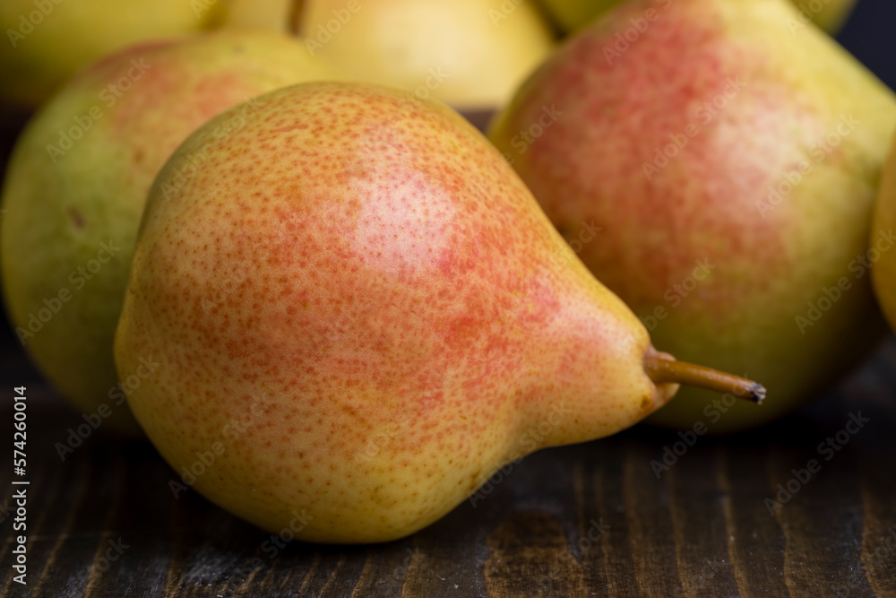 A yellow ripe pear with a red side on the table A yellow ripe pear with a red side on the table