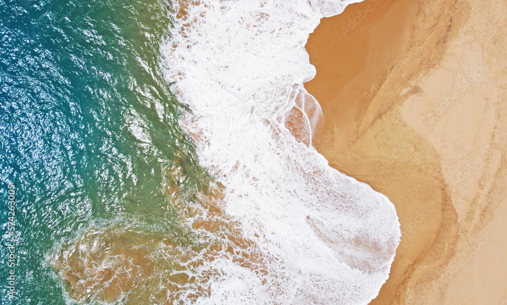 Aerial view of the waves with foam on the sandy ocean shore. Beautiful texture background for tourism and design. Tropical seashore Aerial view of the waves with foam on the sandy ocean shore. Beautiful texture background for tourism and design. Tropical seashore