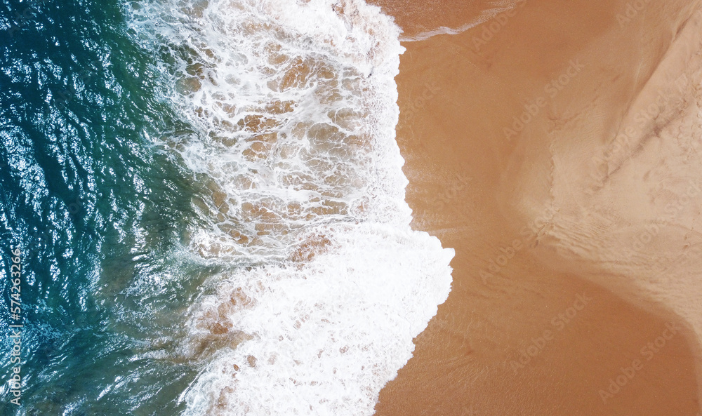 Aerial view of the waves with foam on the sandy ocean shore. Beautiful texture background for tourism and design. Tropical seashore Aerial view of the waves with foam on the sandy ocean shore. Beautiful texture background for tourism and design. Tropical seashore