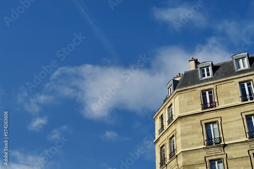 Immeuble ancien blanc en pierre et ciel bleu.
