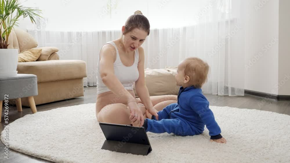 Happy young mother taking care of her baby son and doing fitness exercises and stretching with him. Family healthcare, active lifestyle, parenting and child development. Happy young mother taking care of her baby son and doing fitness exercises and stretching with him. Family healthcare, active lifestyle, parenting and child development.