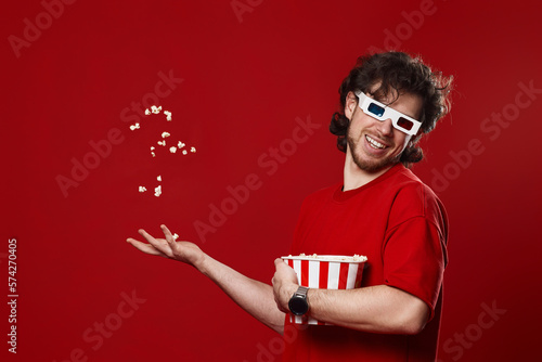 man in 3d glasses, red t-shirt throwing up and eating popcorn