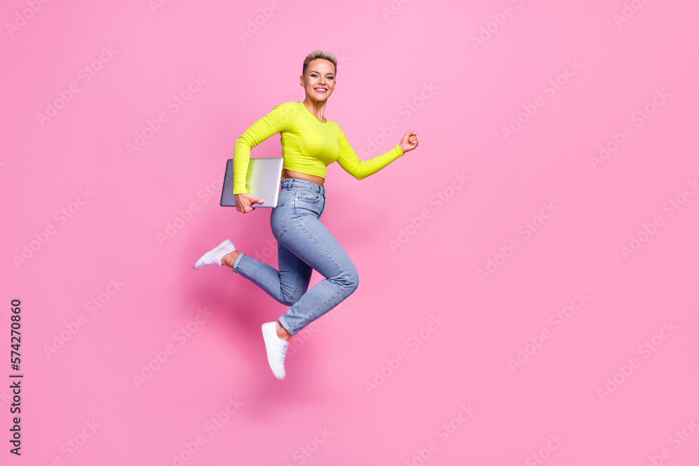 Full length profile photo of overjoyed excited person jump hurry rush hold laptop isolated on pink color background Full length profile photo of overjoyed excited person jump hurry rush hold laptop isolated on pink color background