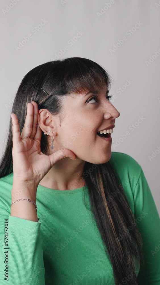 Curious Latin American woman dressed with casual clothing standing on white background while putting hand on ear for listening carefully. Curious Latin American woman dressed with casual clothing standing on white background while putting hand on ear for listening carefully.