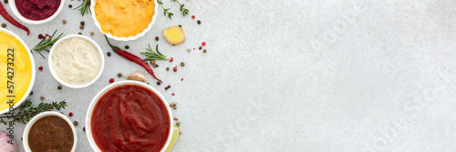 Tableau sur toile Different types of sauces in bowls with seasonings banner, rosemary and pepper,