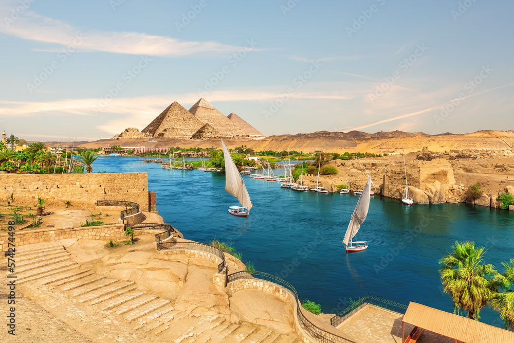 Sailboats and ancient rocks in the Nile on the way to pyramids, Aswan, Egypt