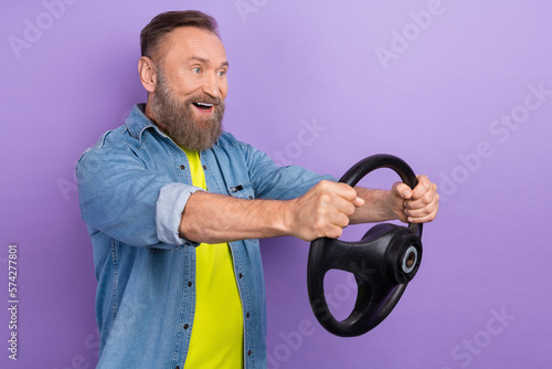 Profile portrait of excited positive person hold wheel look empty space isolated on purple color background