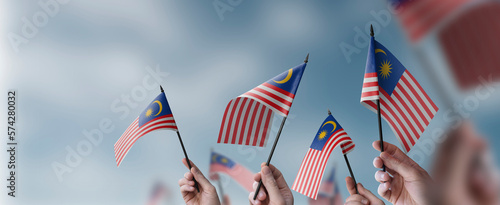 A group of people holding small flags of the Malaysia in their hands photo