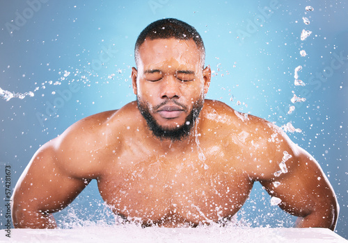 Water splash, cleaning or black man with face wash for skincare, fresh clean hygiene on studio background. African model in beauty, wellness and washing, grooming or cleansing for facial treatment © Mumtaaz D/peopleimages.com