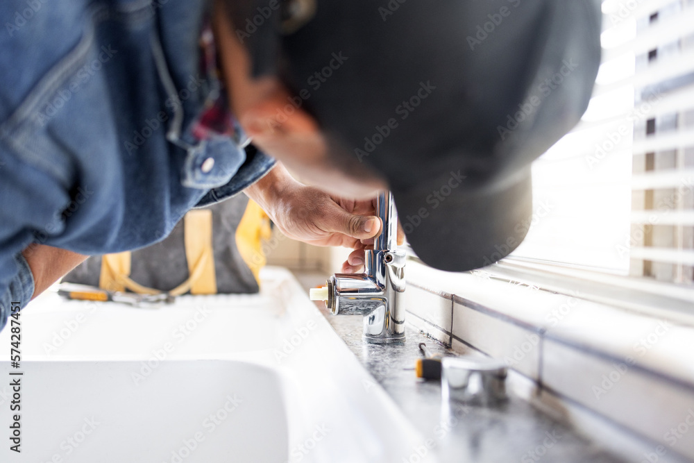 Plumber fixing faucet, plumbing and maintenance with man, manual labour and home renovation with trade. Construction, handyman with kitchen or bathroom sink with hardware, pipe and DIY with vocation Plumber fixing faucet, plumbing and maintenance with man, manual labour and home renovation with trade. Construction, handyman with kitchen or bathroom sink with hardware, pipe and DIY with vocation