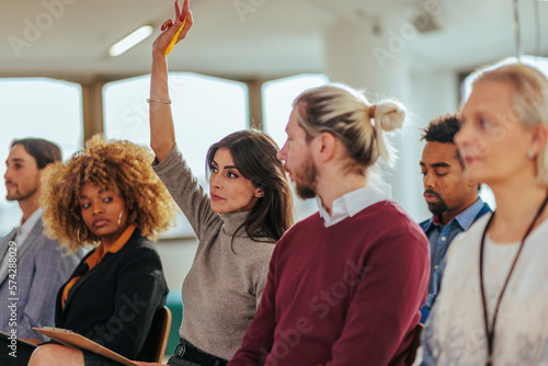 Wall Mural Woman raising hand in meeting.