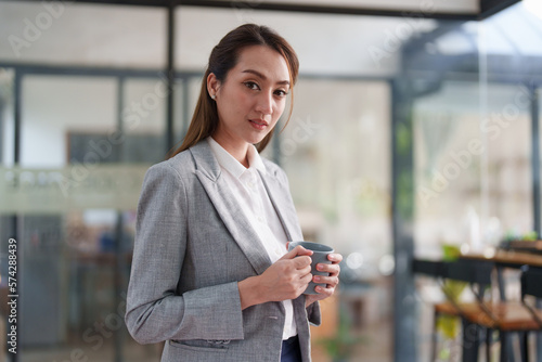 Female employee with coffee at workplace. Businesswoman preparing economic report.