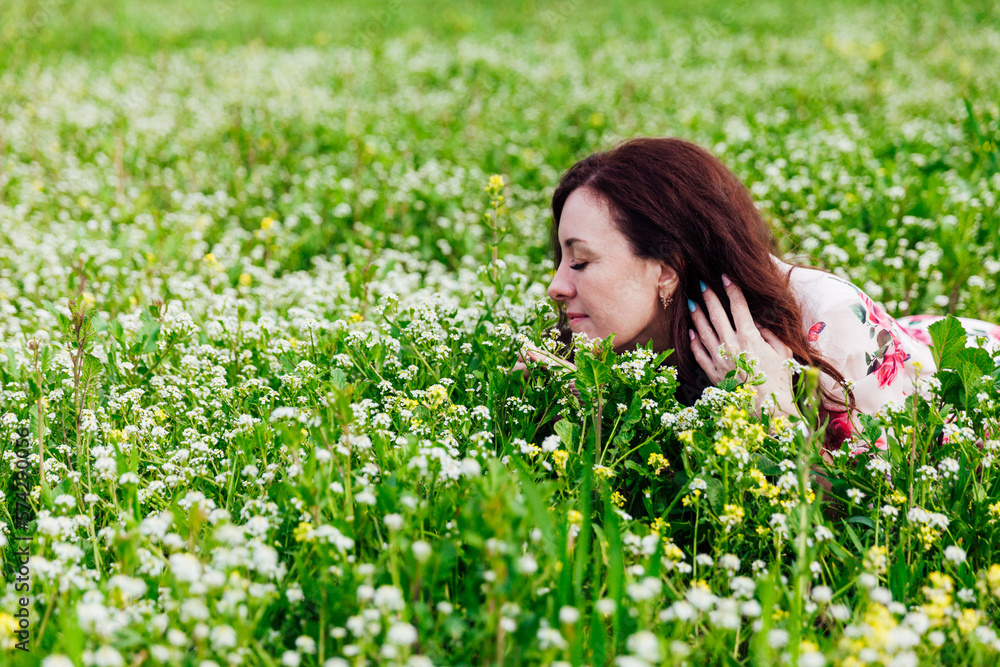 brunette sits in a green clearing in a park in nature brunette sits in a green clearing in a park in nature