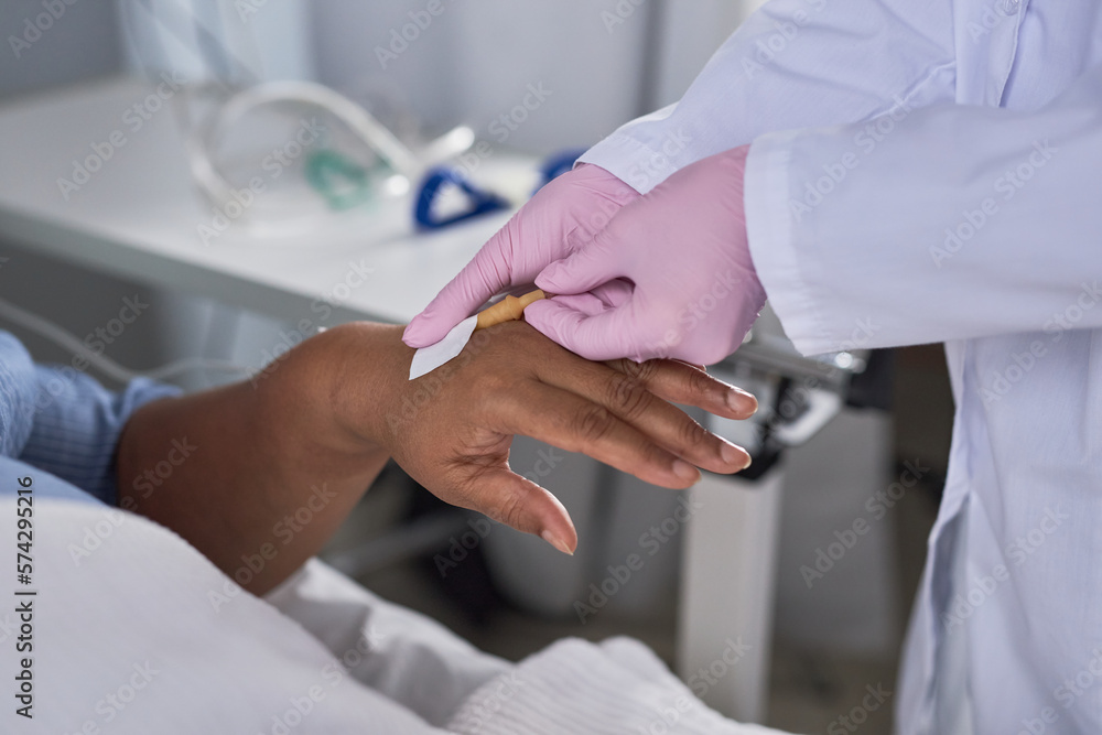 Close up of young nurse placing IV into hand of senior female patient in hospital Close up of young nurse placing IV into hand of senior female patient in hospital