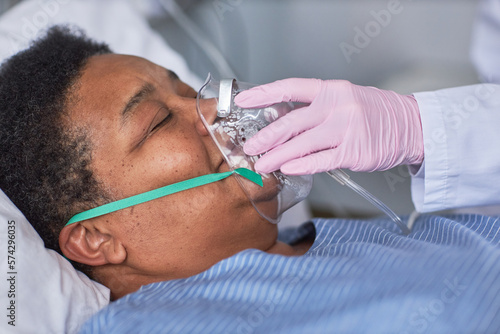 Φωτογραφία Close up of nurse placing oxygen support mask on senior patient in hospital room