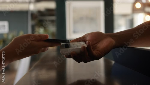 Anonymous Customer Paying with Smart phone on a digital Payment Terminal In a Store Close Up 