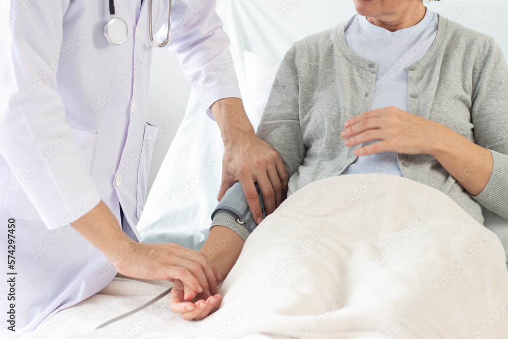 Obraz premium the doctor is examining the patient in the hospital. .Caucasian male doctor measuring blood pressure of female patient in hospital..