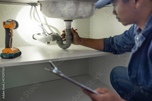 Plumber, sink maintenance check and plumbing data of a handyman in a kitchen. Water pipe installation, home repair checklist and builder in a household for building construction and inspection