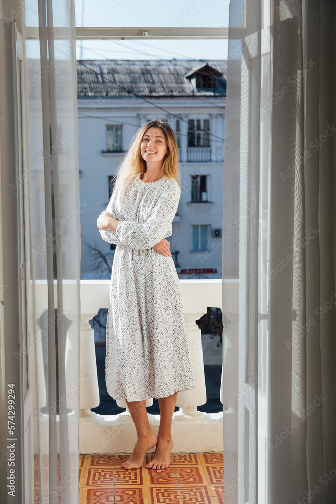 blonde stands on the balcony in the apartment room blonde stands on the balcony in the apartment room