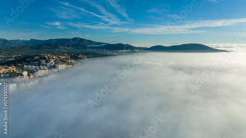 Aerial view  flight above the clouds  the coast of Mallorca in the fog with the town of Santa Ponca  Mallorca  Spain