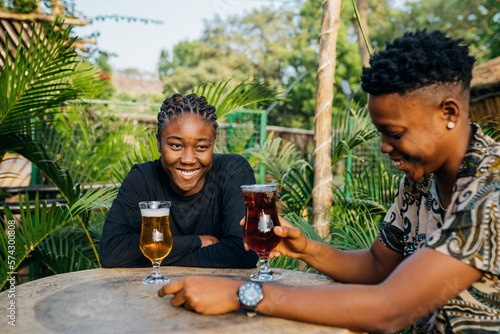Two queer masculine women having a beer