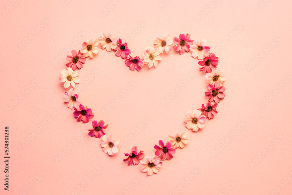 Heart from small pink white flowers on soft pink background, copy space 