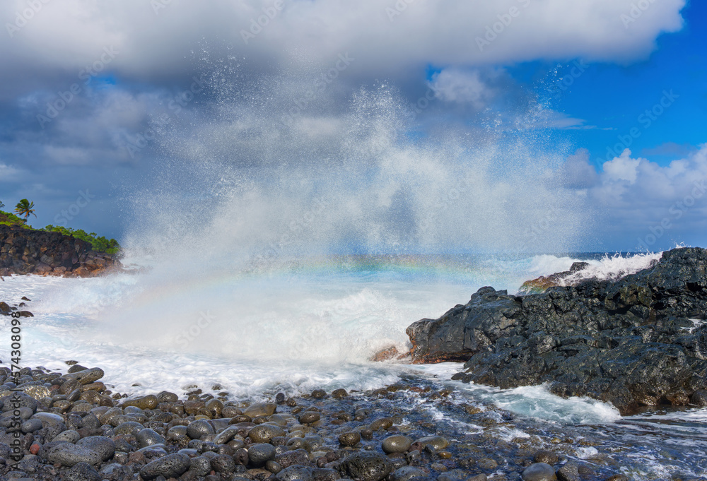Rainbow over the rugged terrain of the Hawaiian coastline