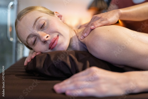 Beautiful young woman lying down on massage beds at luxury massage and spa and wellness center