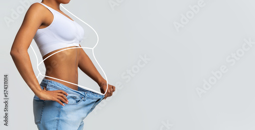 Millennial slim african american lady in big jeans, enjoy weight loss result with fat abstract body around photo