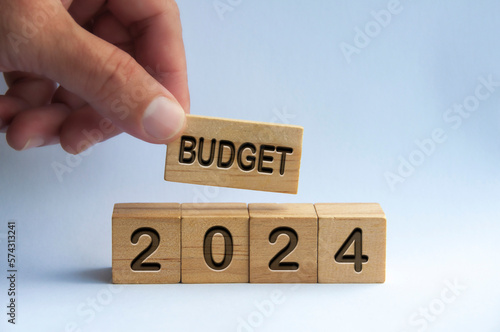 Hand holding wooden block with text - Budget 2024 with blurred nature background. Yearly budget concept