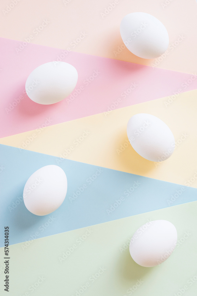 White chicken eggs on multi color background
