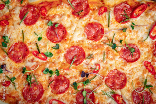 Texture of pepperoni pizza with sausages and hot pepper close-up