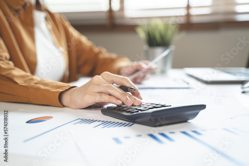 person using calculator calculating tax refund on the table